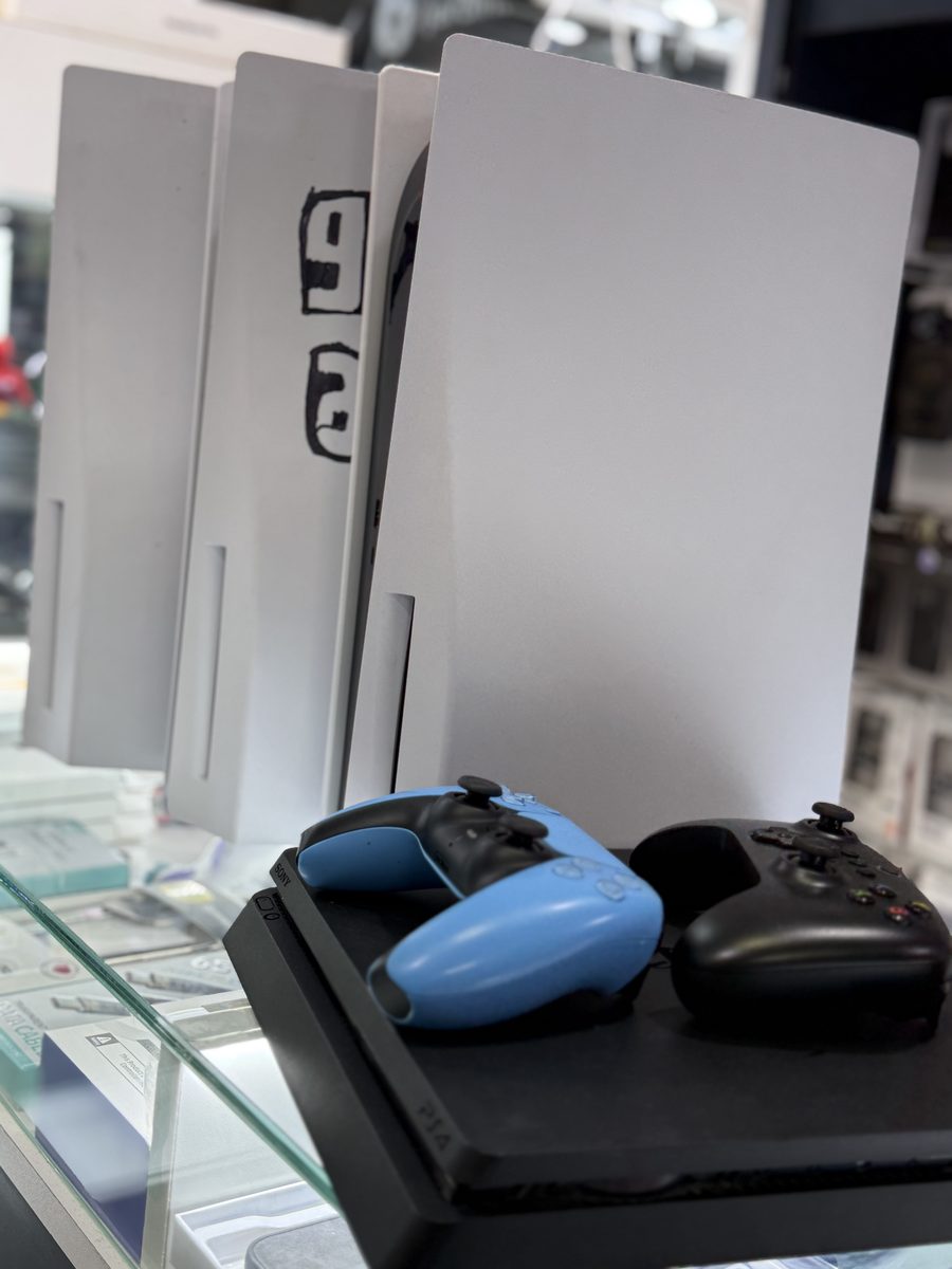 Consolas PlayStation 5 y PS4 con joysticks en exhibición en Smart Case