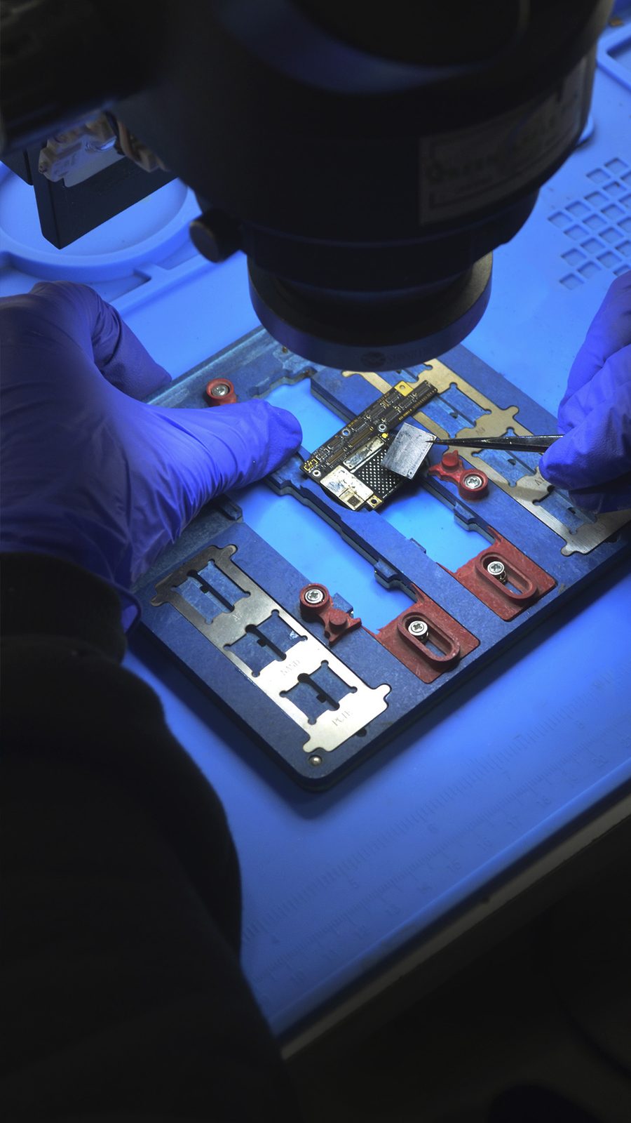 Microsoldadura de precisión con pinzas bajo microscopio