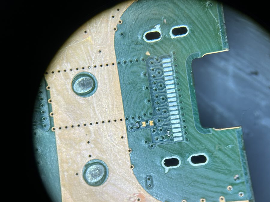 Placa lógica vista al microscopio durante reparación de microsoldadura